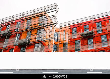 Moderne Baustelle mit Gerüsten und leerem Informationszaun, Horten mit Kopierfläche für Branding- oder Entwicklungsprojekt-Informationen Stockfoto