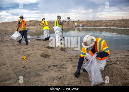 Eine Reinigungscrew reinigt Öl- und Teerbeläge und küst einen Berm hoch, der gebaut wurde, um zu verhindern, dass sich Öl in den Santa Ana-Fluss ausbreitet, der normalerweise fließt Stockfoto