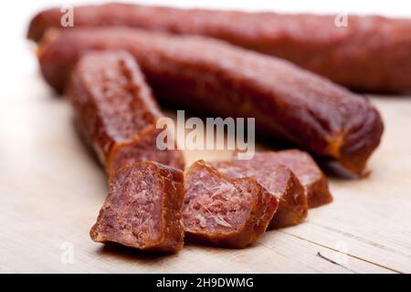 Geräucherte Würstchen, Würstchen, Holzbrett, Fett, schließen, Wurst, geräuchert, Österreich, Brett, getrocknet, Mehrfach, braun, Hintergrund, weiß, Detail, Holz, Studio Stockfoto