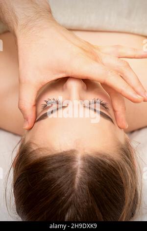 Gesichtsmassage mit den Fingern eines Masseurs. Weibliche Gesichtshautpflege in einem Schönheitssalon Stockfoto
