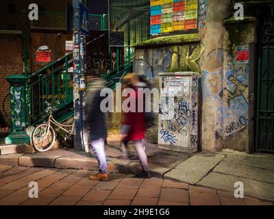 Mailand, Lombardei, Italien. Dezember 2019. Menschen, die nachts vor der façade einer typisch italienischen Pizzeria in Mailand vorbeikommen. Stockfoto