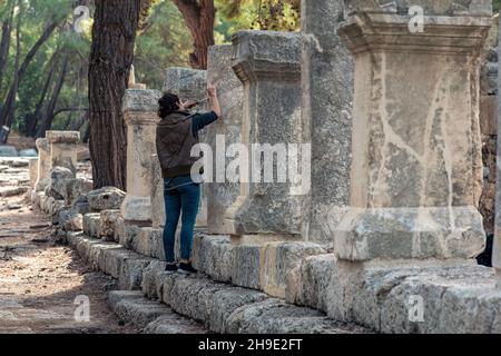 Phaselis, Türkei - 08. November 2021: Archäologe stellt eine alte Inschrift auf einer Säule wieder her Stockfoto