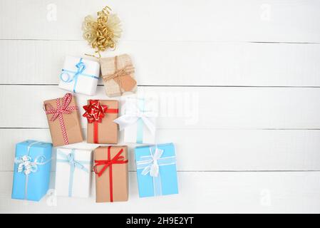 Weihnachtliche Flache Laie. Geschenke verpackt und in Form eines Weihnachtsbaums mit Kopierfläche auf weißen rustikalen Brettern. Stockfoto