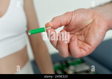 Der Arzt hält kleine Ampullen in den Händen. Nahaufnahme einer kleinen Ampulle mit einem Impfstoff in der Hand des Arztes. Reagenzglas für Allergietest halten. Allergietests Stockfoto