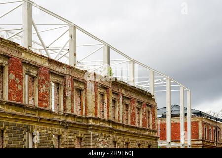 Integration der Fassade des alten Backsteingebäudes in ein neues, modernes Industriegehäuse aus Metall Stockfoto