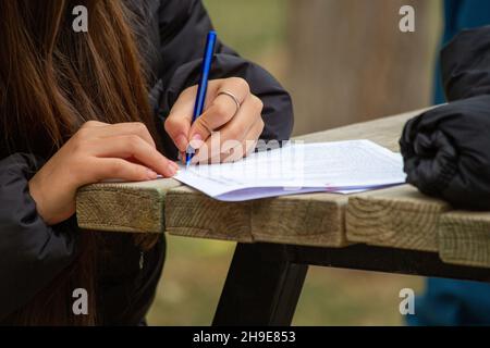 Junge männliche Hände füllen Formulare aus. Junger Mann schreibt. Stockfoto