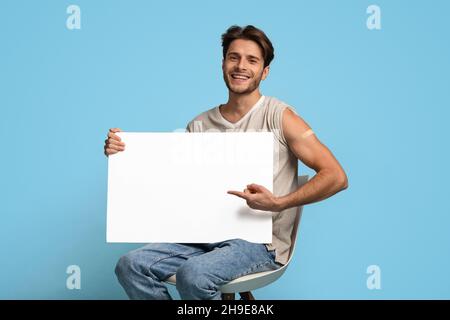 Impfwerbung Geimpfter Junger Mann, Der In Seinen Händen Auf Blank Placard Zeigt Stockfoto