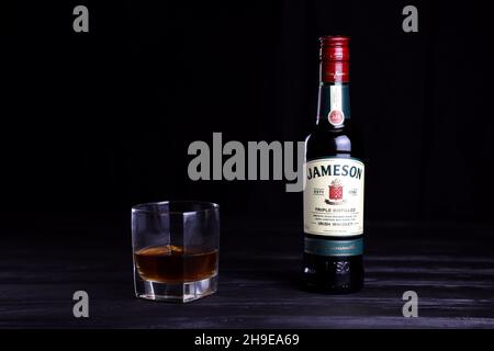 KHARKOV, UKRAINE - 3. DEZEMBER 2020: Jameson dreifach destillierte irische Whiskyflasche auf dunkelschwarzem Hintergrund. Elite-Alkoholproduktion Stockfoto