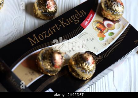 CHARKOV, UKRAINE - 19. April 2021: Henry Lambertz Mozart-Kugeln luxuriöse dunkle Schokolade Bonbons in schwarzer Box auf weißem Holztisch Stockfoto