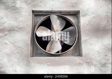 Ein Wandventilator in einem unscheinbaren Gebäude sorgt für Belüftung in der feuchten Luft von Havanna. Stockfoto