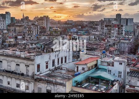 Ein Blick auf den Stadtteil Vedado in Havanna, Kuba wird von einem orangen Sonnenuntergang in der Ferne gefärbt. Stockfoto