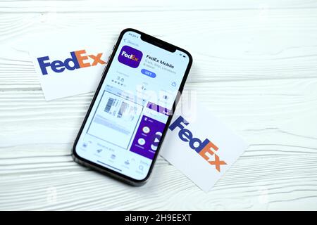 CHARKOV, UKRAINE - 5. MÄRZ 2021: FedEx-Symbol und Anwendung aus dem App Store auf dem iPhone 12 pro Display-Bildschirm auf weißem Holztisch Stockfoto