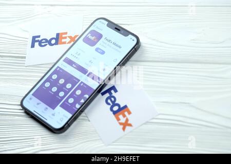 CHARKOV, UKRAINE - 5. MÄRZ 2021: FedEx-Symbol und Anwendung aus dem App Store auf dem iPhone 12 pro Display-Bildschirm auf weißem Holztisch Stockfoto