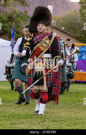 Eine Highland Drum Major in ihrer vollen Regalia und Mace führt eine Pfeifenband auf einem schottischen Festival in Moab, Utah. Stockfoto