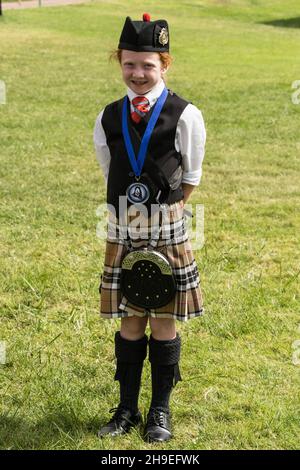 Ein junges Mitglied einer schottischen Highland-Pfeifenband in ihrer Glengarry-Haube und ihrem Kilt auf einem Festival in Utah. Stockfoto
