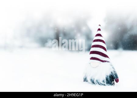 Frohe weihnachten, kleiner und niedlicher Zwerg mit Hut auf dem Schnee, nützlich für Postkarte, Poster Stockfoto