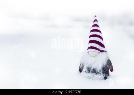 Frohe weihnachten, kleiner und niedlicher Zwerg mit Hut auf dem Schnee, nützlich für Postkarte, Poster Stockfoto