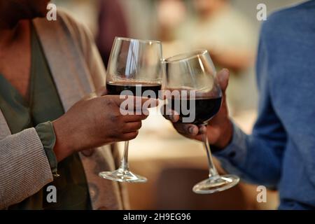 Nahaufnahme eines afroamerikanischen Paares, das Weingläser anklimmte, während es zu Hause ein romantisches Abendessen genießt Stockfoto