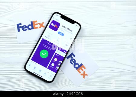 CHARKOV, UKRAINE - 5. MÄRZ 2021: FedEx-Symbol und Anwendung aus dem App Store auf dem iPhone 12 pro Display-Bildschirm auf weißem Holztisch Stockfoto