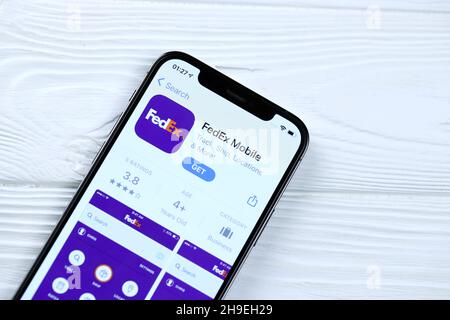 CHARKOV, UKRAINE - 5. MÄRZ 2021: FedEx-Symbol und Anwendung aus dem App Store auf dem iPhone 12 pro Display-Bildschirm auf weißem Holztisch Stockfoto