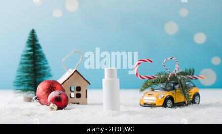 Weihnachtlicher Hintergrund mit einem Nachbau einer weißen Flasche mit einem Gesichtskosmetik auf dem Schnee. Ein kosmetisches Produkt als Geschenk. Stockfoto