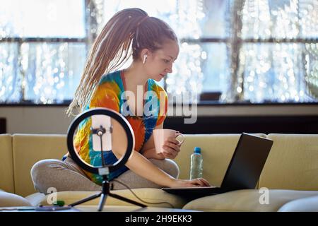 Weibliche Vlogger ist dabei, ihre Streaming-Ausrüstung zu einrichten. Stockfoto