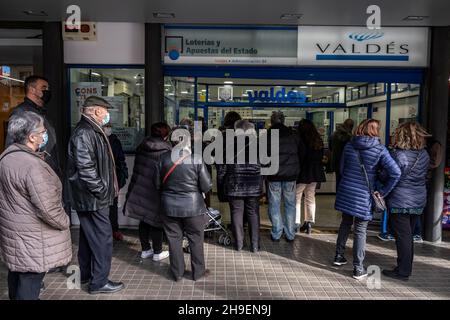 Barcelona, Spanien. 06th Dez 2021. Eine lange Schlange von Menschen wartet darauf, dass sie an der Reihe sind, um Weihnachtslotteriekarten zu kaufen.wie es jedes Jahr in den Wochen vor Weihnachten Tradition ist, warten lange Schlangen von Menschen bei der Lotterieverwaltung von Valdés auf der Rambla, um Weihnachtslotteriekarten zu kaufen. Kredit: SOPA Images Limited/Alamy Live Nachrichten Stockfoto