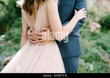 Der Bräutigam umarmt die Taille der Braut. Nahaufnahme Stockfoto