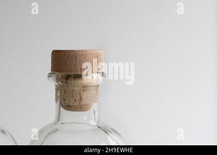 Korkstopfen in durchsichtiger Glasflasche für Flüssigkeiten auf hellem Hintergrund Stockfoto