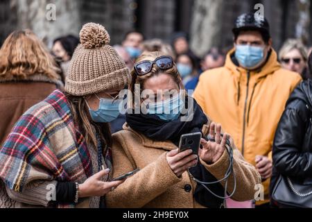 Barcelona, Spanien. 06th Dez 2021. Zwei Frauen, die eine Gesichtsmasken tragen, sehen in ihre Handys.viele Menschen nutzen den zweiten arbeitsfreien Tag mit Ladeneröffnung, um in Erwartung von Weihnachten einzukaufen. Aufgrund der steigenden Covid-19-Infektionen werden Käufer mit Schutzmasken beobachtet. Kredit: SOPA Images Limited/Alamy Live Nachrichten Stockfoto