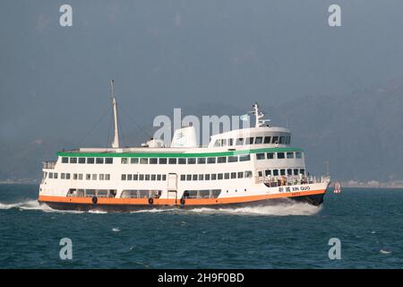 „Xin Guo“ („New Country“) – ein Schiff der ersten Fährgesellschaft, das vom 30. November 2021 durch den Victoria-Hafen von Cheung Chau nach Central, Hongkong, fährt Stockfoto