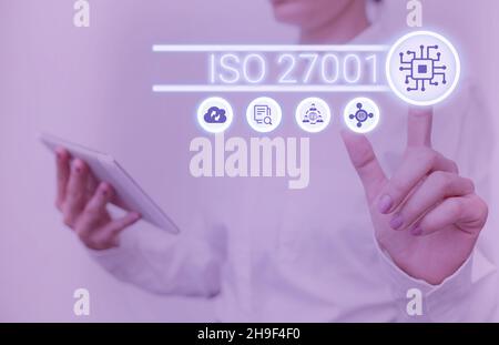 Schild mit ISO 27001. Wort geschrieben auf Spezifikation für ein Informationssicherheits-Management-System Lady Holding Tablet Drücken auf virtuelle Taste Stockfoto