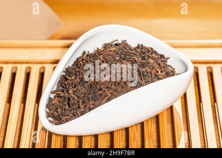 Stark fermentierter chinesischer Shu Puer Gong Ting Jin Ya oder Palace Golden Knospen Tee in einem Tee-Präsentationsgefäß Stockfoto