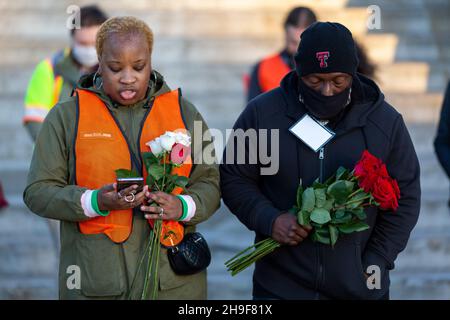 Fort Worth, Texas, USA. 6th Dez 2021. Vor hundert Jahren wurde ein schwarzer Mann namens Fred Rouse von einem wütenden Mob weißer Männer aus Fort Worth, Texas, ermordet. Heute 12/06/2021, in Fort Worth, Texas, in der Nähe eines beliebten Touristengebiets namens The Stockyards, wo früher Rinder zur Versteigerung verkauft wurden, aber jetzt ein Ort für einen Vorgeschmack auf das Cowboy-Leben ist. Eine Gruppe von fünfundzwanzig Personen versammelte sich, darunter Fred Rouse, der zweite, der Urenkel des verstorbenen Herrn Rouse. Die Gruppe hielt die erste Mahnwache mit 100 Rosen ab, eine Rose für jedes Jahr, in dem sein Leben in der Geschichte vergessen wurde. (Bild: © Chris Rusan Stockfoto