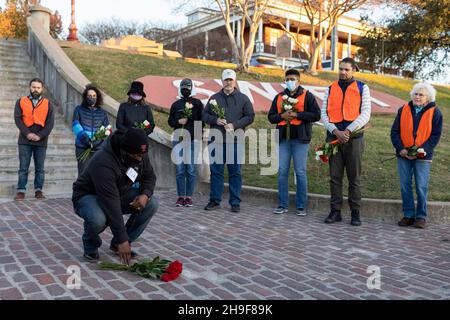 Fort Worth, Texas, USA. 6th Dez 2021. Vor hundert Jahren wurde ein schwarzer Mann namens Fred Rouse von einem wütenden Mob weißer Männer aus Fort Worth, Texas, ermordet. Heute 12/06/2021, in Fort Worth, Texas, in der Nähe eines beliebten Touristengebiets namens The Stockyards, wo früher Rinder zur Versteigerung verkauft wurden, aber jetzt ein Ort für einen Vorgeschmack auf das Cowboy-Leben ist. Eine Gruppe von fünfundzwanzig Personen versammelte sich, darunter Fred Rouse, der zweite, der Urenkel des verstorbenen Herrn Rouse. Die Gruppe hielt die erste Mahnwache mit 100 Rosen ab, eine Rose für jedes Jahr, in dem sein Leben in der Geschichte vergessen wurde. (Bild: © Chris Rusan Stockfoto