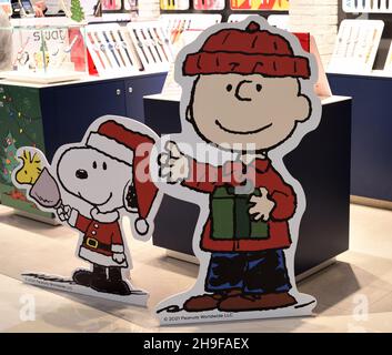 Pappfiguren von lächelndem Charlie Brown und Snoopy im Weihnachtskostüm, um Kunden in einer Einkaufspassage in Hongkong zu begrüßen. Stockfoto