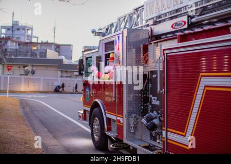 Sparky, das Maskottchen der National Fire Protection Association, begrüßt die Gäste während einer jährlichen Baumpflicht-Zeremonie in der Marine Corps Air Station Iwakuni, Japan, am 4. Dezember 2021. Die Zeremonie bot der lokalen Gemeinde die Gelegenheit, die Weihnachtszeit zu begrüßen, und zeigte Musik von lokalen Studenten, Essensstände, eine Schneemaschine, einen hässlichen Pullover-Wettbewerb und einen Besuch vom Weihnachtsmann. (USA Marine Corps Foto von CPL Ann Bowcut) Stockfoto