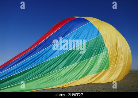 Teilweise entlüfteter Heißluftballon auf dem Boden Stockfoto