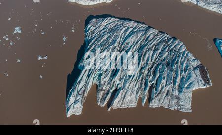 Bick Block von Gletschereis aus großen Gletscher in hoffell, island, im braunen Wasser schwimmend gebrochen. Stockfoto