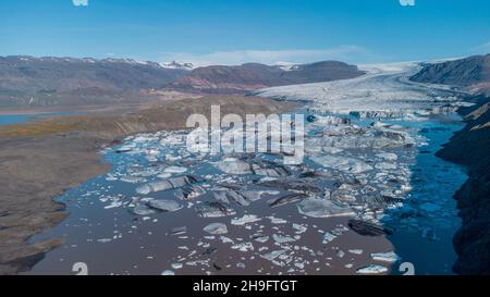 Bick-Blöcke von Gletschereis aus dem großen Gletscher in hoffell, island, gebrochen, schwimmend in braunem Wasser. Stockfoto