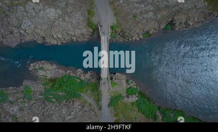 Brücke über den Fluss in island. Direkte Luftaufnahme einer Brücke über stilles Wasser. Stockfoto