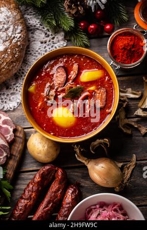 Top of view bei der Kohlsuppe - Kapustnica und Zutaten für die Zubereitung: Sauerkraut, Wurst, geräucherter Hals und Knie, Kartoffeln, Zwiebeln, getrockneter Moschus Stockfoto