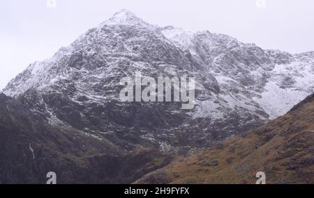 Winter im Snowdonia National Park (Eryri), Wales, Großbritannien. Schnee auf dem Gipfel des Snowdon (Yr Wyddfa), dem höchsten Berg in Wales, von der Bergarbeiterspur aus gesehen, als sich der Sturm Barra nähert. Es wird erwartet, dass starke Winde und Schnee das vereinigte königreich treffen werden. Der Berg liegt 1.085 Meter (3.560 Fuß) über dem Meeresspiegel und ist der höchste Punkt der Britischen Inseln außerhalb der schottischen Highlands. Stockfoto