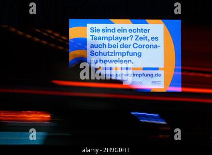 Dresden, Deutschland. 07th Dez 2021. Autos fahren am Morgen an einer LED-Wand vorbei, die die Corona-Impfung anwirbt. Quelle: Robert Michael/dpa-Zentralbild/dpa/Alamy Live News Stockfoto