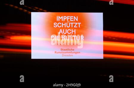 Dresden, Deutschland. 07th Dez 2021. Am Morgen fahren Autos an einer LED-Wand vorbei, an der die State Art Collections (SKD) die Impfung gegen Covid-19 ankündigt. Quelle: Robert Michael/dpa-Zentralbild/dpa/Alamy Live News Stockfoto