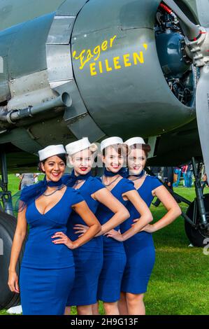 Zeitraum weibliche Flight Attendant Kostüme am Goodwood Revival 2014 im Freddie März Geist der Luftfahrt. Frauen in der Zeit von Kleid. C-47 Dakota Stockfoto