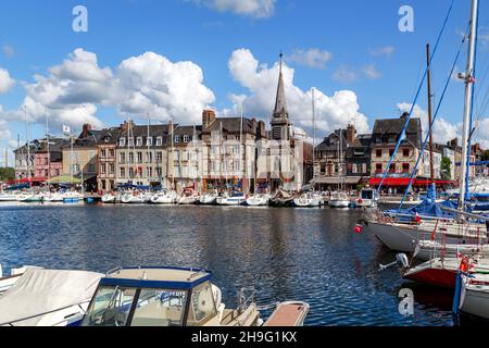 HONFLEUR, FRANKREICH - 1. SEPTEMBER 2019:Blick auf den Quai Saint Etienne mit der mittelalterlichen Kirche Saint Etienne (14th. Jahrhundert) und der Jachtpier Stockfoto