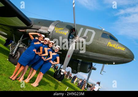 Zeitraum weibliche Flight Attendant Kostüme am Goodwood Revival 2014 im Freddie März Geist der Luftfahrt. Frauen in der Zeit von Kleid. C-47 Dakota Stockfoto