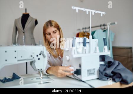 Schneiderei arbeitet an der Nähmaschine am Arbeitsplatz Stockfoto