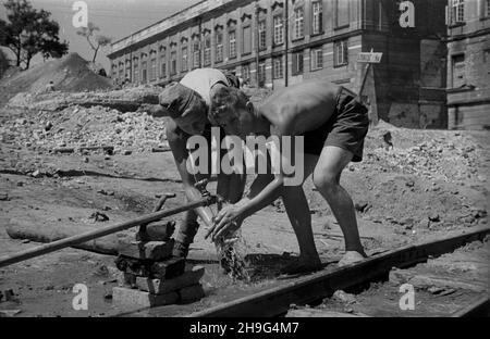 Warszawa, 1948-06. Budowa Trasy Wschód-Zachód (Trasa W-Z). NZ. Junacy z 2 brygady zgrupowania warszawskiego Powszechnej Organizacji S³u¿von Polsce pracuj¹cy przy odgruzowywaniu terenu pod budowê. W tle barokowy pa³ac Pod Blach¹ projectu Jakuba Fontany, zniszczony podczas II wojny œwiatowej. As PAP Dok³adny dzieñ wydarzenia nieustalony. Warschau, Juni 1948. Der Bau der W-Z-Strecke. Im Bild: Mitglieder der 2nd Brigade der Warschauer Gruppe des Massenorganisationsdienstes nach Polen, die Schutt auf einer Baustelle abbauen. Im Hintergrund das barocke Pod Blacha (Metalldach) Pala Stockfoto